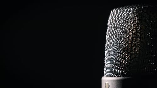 Studio Microphone Rotates on a Black Background in Backlight CloseUp