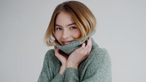 Smiling Young Woman in Cozy Green Sweater Holding Collar
