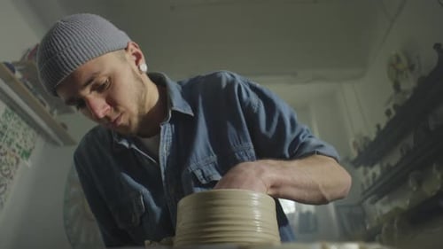 A European Master Potter Works on a Potter's Wheel with Clay
