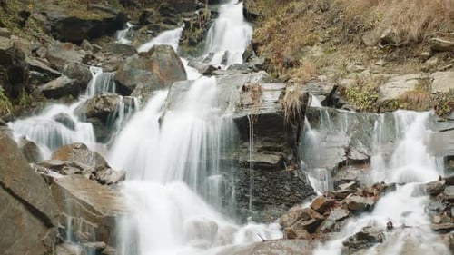 Small Waterfalls in the Mountainous Area Flowing Down Stone Blocks in Autumn