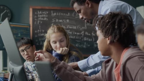 Teacher Guides Students in Computer Classroom