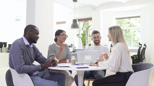 Four Adults Collaborating on a Laptop in Office