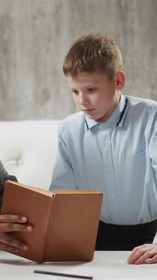 AfricanAmerican Man Shows Exercise in Textbook to Student