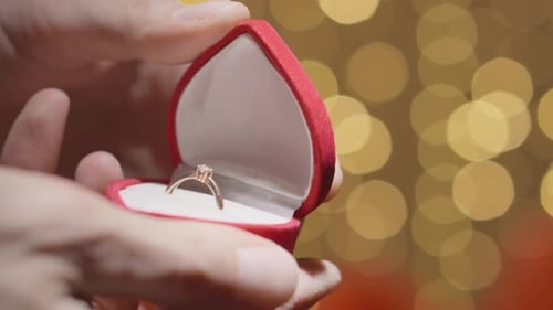 Hands Holding Engagement Ring in Box
