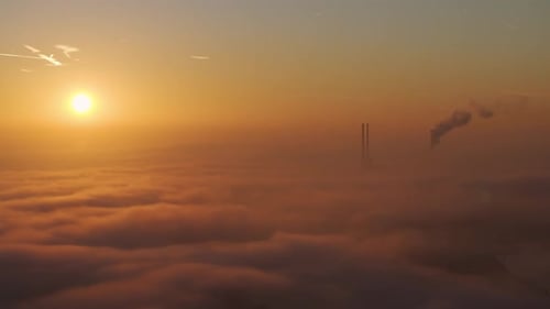 Dreamy Sunset Over Clouds with Industrial Smokestack