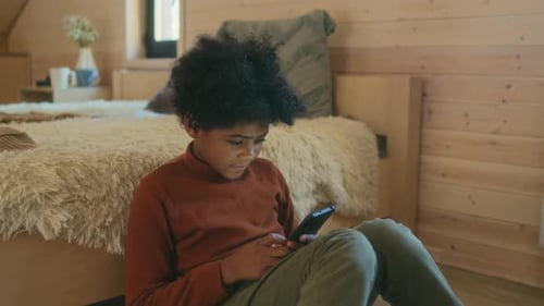 Child Using Smartphone in Cozy Bedroom