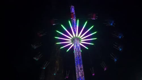 Brightly Lit Swing Ride Spinning at Night at Edinburgh Christmas Market