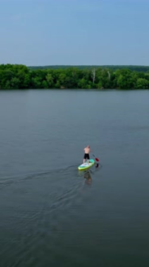 Paddleboarding on a Calm Lake with Trees