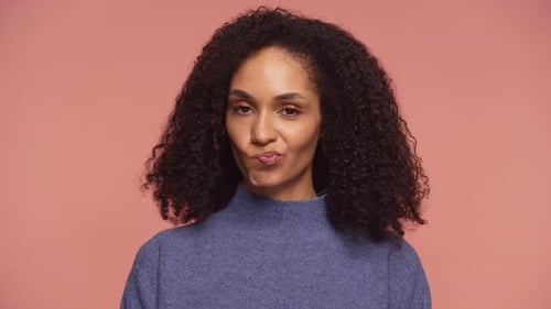 Femme secouant la tête en signe de désapprobation avec les lèvres pincées sur fond rose