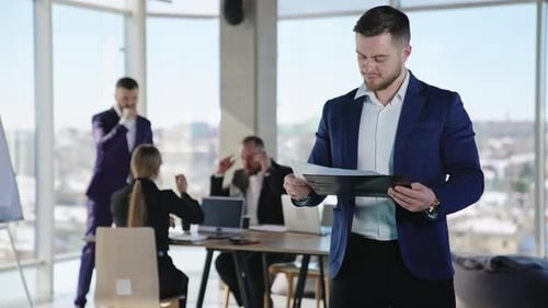 Adults in a modern office with laptops
