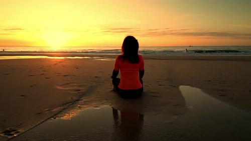 Camera Flying Around Woman Sitting in Meditation Pose Sunset on Vietnam Beach Lotus Position