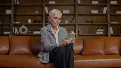 Woman Using Smartphone on Sofa