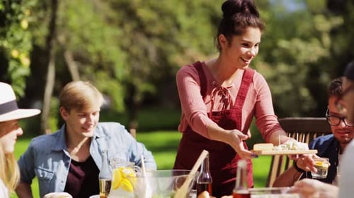 Friends enjoying sunny outdoor lunch with salad