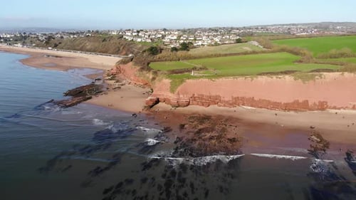 Aerial View Of Orcombe Beach And Cliff Coastline In Exmouth With Visitors On Beach On Sunny Day. Dol