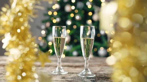 Festive Champagne Flutes with Christmas Tree Background