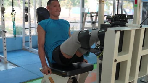 Disabled athletic exercising on machine in fitness gym 4k