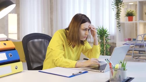 Young female entrepreneur working hard and busy using laptop at home office desk.