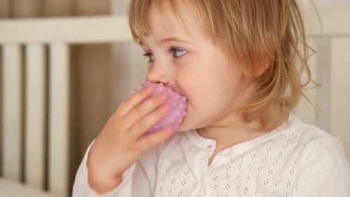 Cute Child with Blonde Hair Plays with Toy