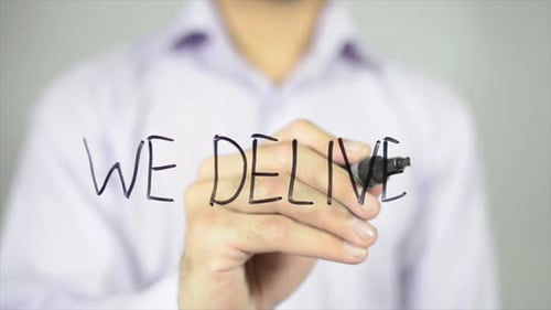 Hand Writes 'We Deliver' on Glass Surface