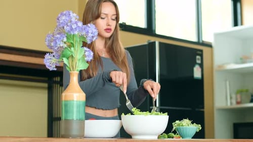Woman Prepares Healthy Salad in Bright Kitchen
