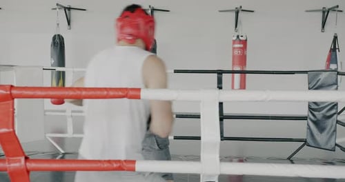Zeitlupe von Boxern, asiatischen und kaukasischen Männern, die in einem modernen Fitnessstudio kämpfen, konzentriert auf das Training