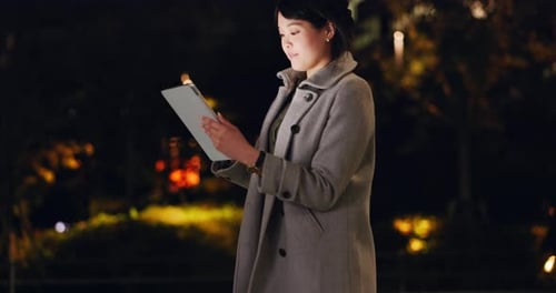 Night, thinking and Japanese woman with a tablet for gps location, email or a search in the city