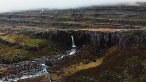 Footage from far into the mountains of Iceland. Aerial going towards a majestic waterfall.