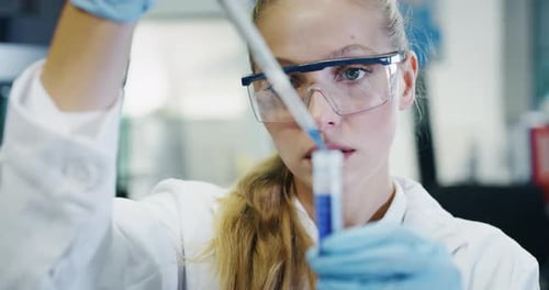 Scientist Using Pipette Adding Liquid to Test Tube