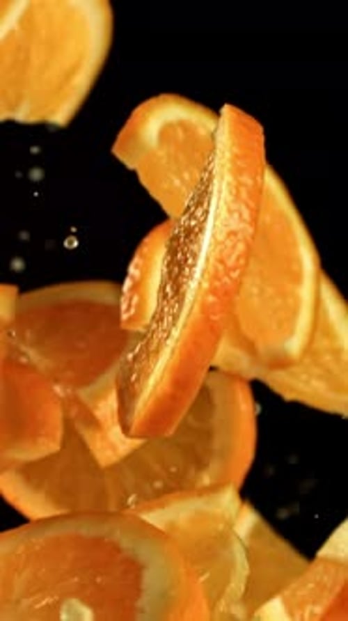 Orange Slices Flying on a Black Background Filmed on a Highspeed Camera at 1000 Fps