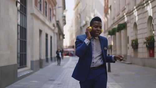Man Dances Down City Street with Headphones