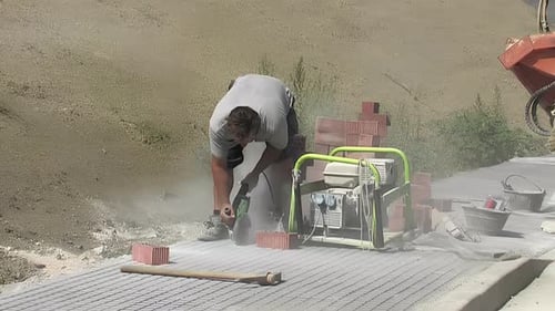 Man Cutting Bricks with Power Tool Outside