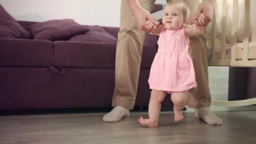 Beautiful Baby Girl Stand Up with Father Support. Infant Learning Walk. Child