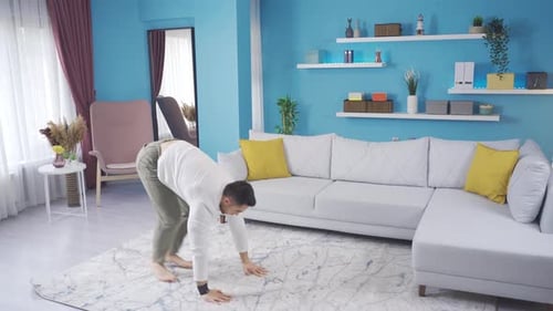 Jeune homme au corps en forme faisant du burpee pour développer ses muscles à la maison.
