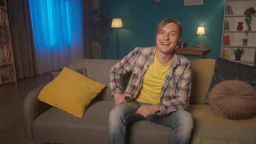 Man Laughing Watching TV on Couch at Home