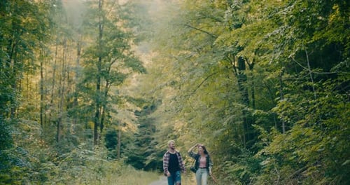 Happy Friends Strolling Amidst Trees In Forest