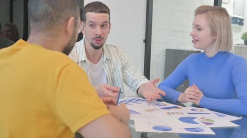 Team Discussing Data Charts in Modern Office