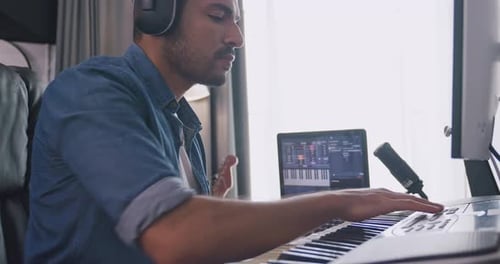 Asian musician is creating new music in his home studio.