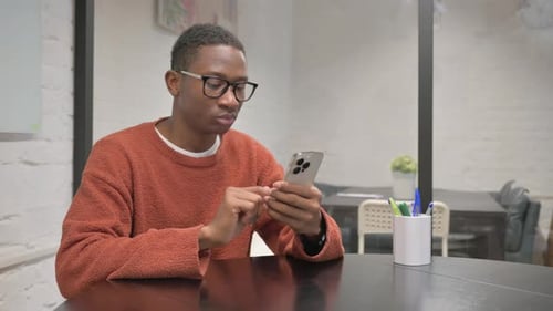 Young Adult Using Smartphone in Office Setting