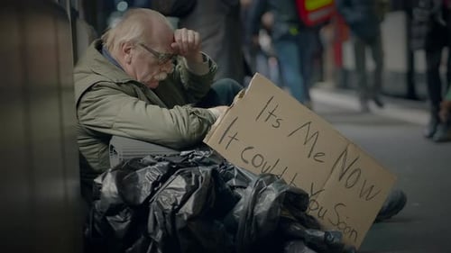 Senior Man Sitting on Street with Sign