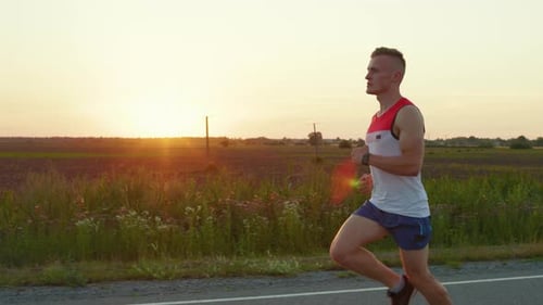 Sporty Young Male Running Down Road in Countryside