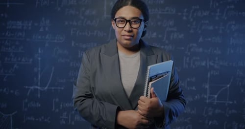 Slow Motion Portrait of African American Lady School Teacher Standing in Class Holding Books with