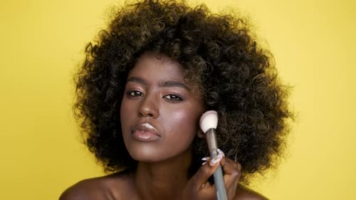 Smiling Ethnic Woman Applying Makeup with Brush