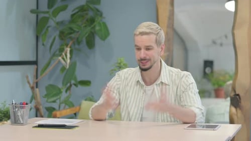 Man Talking at Desk in Office