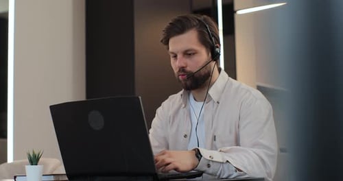 Young Businessman Working on Laptop Wearing Headset Freelance Worker Call Center or Support Service