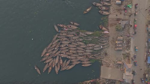 Traditional rowboats docked at crowded Buriganga River in Dhaka urban environment