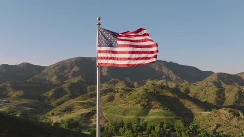 American Flag Waving over Rolling Green Hills