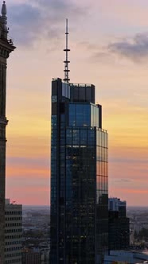 Aerial drone view of the Warsaw Trade Tower featuring its rooftop antenna, set against an overcast e