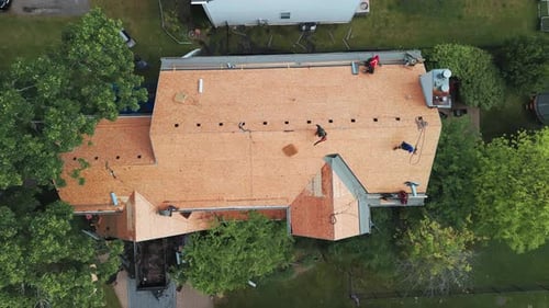 Roofers Installing a New Roof on an Residential Building Top Down Shot