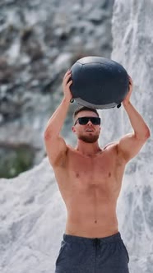 Homme faisant de l'exercice du medicine-ball à l'extérieur.