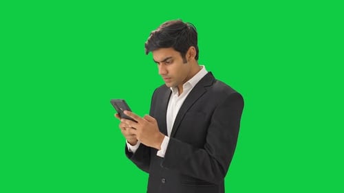 Indian businessman texting on phone Green screen
